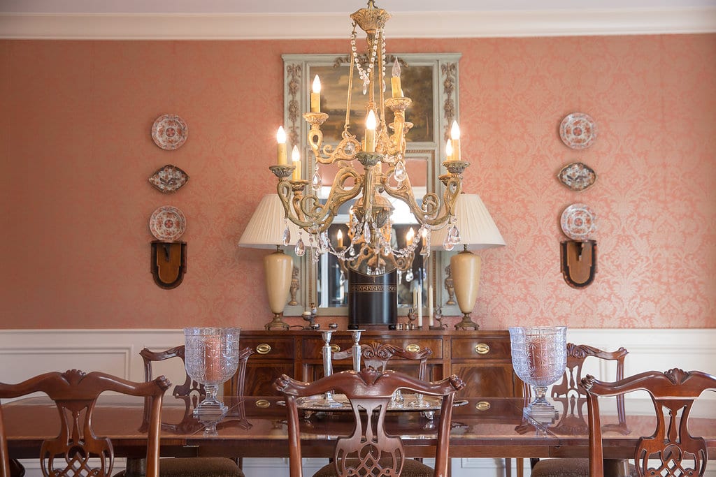 coral-damask-wallpaper-dining-room-chippendale-chairs -chandelier-hanging-plates-on-wall-antique-sideboard - The Glam Pad
