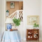skirted-round-table-shells-shell-art-grasscloth-blue-and-white-chinoiserie-lamp-railing-staircase-botanical-prints-framed