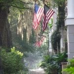 southern-charm-spanish-moss-cobblestone-streets-canopy-trees-american-flag