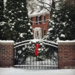red-brick-home-black-shutters-iron-gate-wreath-red-bow-christmas-federalist-colonial-federal-snow