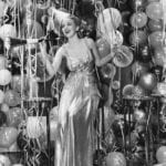 1930s-style-new-years-eve-celebration-balloons-streamers-noise-maker-glamourous-shimmery-dress-party-hat-vintage-retro