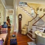 yellow-living-room-staircase-antique-clock-paintings-portrait