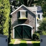 shingle-carriage-house-black-garage-door-window-boxes-white-gate