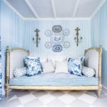 blue-and-white-striped-wallpaper-chintz-transferware-plates-hanging-on-wall-antique-french-daybed-painted-floor