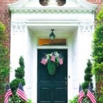 colonial-style-house-front-door-red-brick-decorate-with-flags-planters-wreath-fourth-of-july