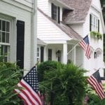fourth-of-july-american-flag-white-brick-house-black-shutters-patriotic-landscape-decoration-classic