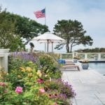 custom Chippendale-inspired wood fence and fieldstone wall terrace blue white planters american flag