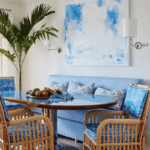 ellen-kavanaugh-interior-design-blue-and-white-breakfast-room-rattan-chairs-furniture-banquette-palms-abstract-art