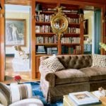 miles-redd-orange-lacquered-library-bookcases-with-sconces-brown-velvet-tufted-sofa-federal-convex-mirror-interior-design