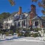 christmas-wreaths-hanging-on-windows-red-bows-ribbons-snow-colonial-house