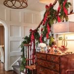 victoria-magazine-stairs-staircase-garland-red-ribbons-evergreen-entry-nutcrackers-christmas-holiday-decorating