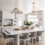 rachel-parcell-white-marble-kitchen-island-brass-pendants-sconces-traditional-home