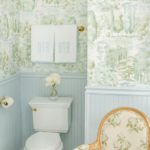 tori-alexander-interiors-nashville-bathroom-wallpaper-wainstcotting-blue-gren-brass-accents-monogrammed-weezie-towels-colefax-fowler-bowood-chintz-french-chair