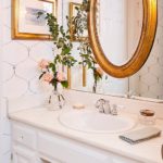 Minnette Jackson white marble powder room gold mirror hang over mirror