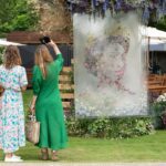 Visitors look at a floral installation depicting Britain’s Queen Elizabeth called “Natural Perspectives” by Veevers Carter at the RHS Chelsea Flower Show during press day in London, May 23, 2022…RHS/Suzanne Plunkett